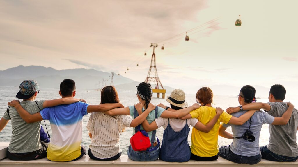 A group of people sitting on the side of a body of water.